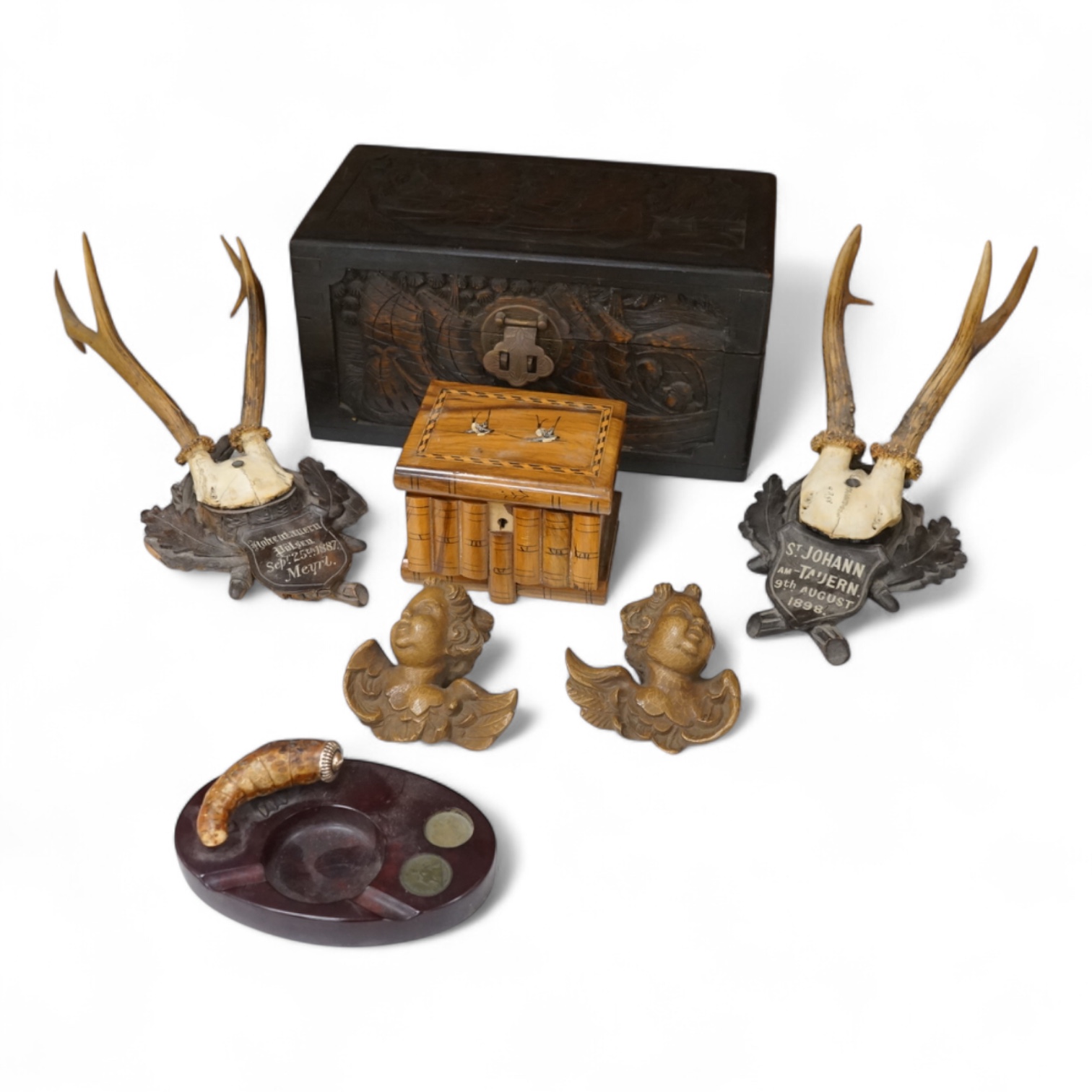 A Chinese carved wood box, two pairs of mounted deer horns, two carved wood cherub heads, an ashtray and an olivewood box, large box 29.5cm x 15cm high. (7)